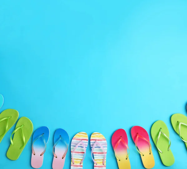 Diverse infradito e spazio per il testo su sfondo blu, posa piatta. Accessori spiaggia estate — Foto Stock