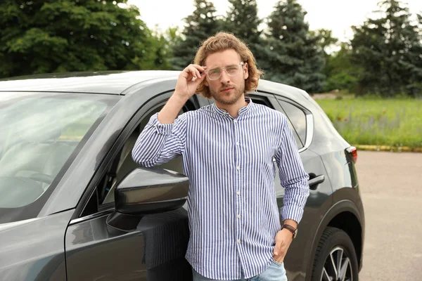 Jeune homme attrayant près de voiture de luxe à l'extérieur — Photo
