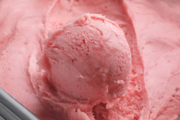 Colher de delicioso sorvete de morango em recipiente, close-up — Fotografia de Stock