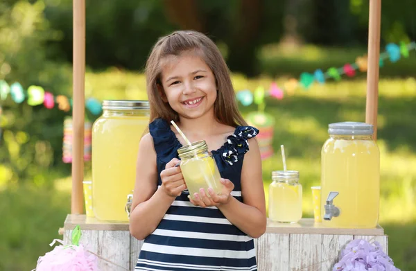 Söt liten flicka med naturlig lemonad i parken. Sommar uppfriskande drink — Stockfoto