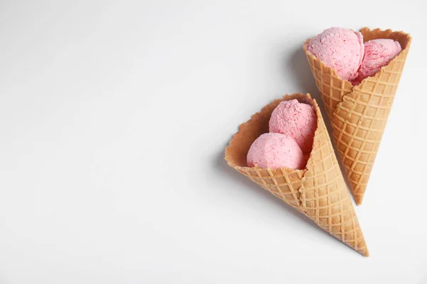 Deliciosos sorvetes em cones de bolacha no fundo branco, vista superior — Fotografia de Stock