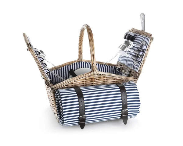 Wicker basket with picnic essentials and blanket on white background — Stock Photo, Image