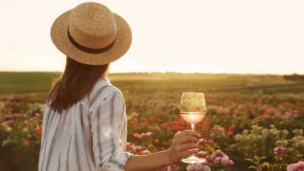 Mujer con copa de vino en jardín de rosas en un día soleado. Espacio para texto —  Fotos de Stock