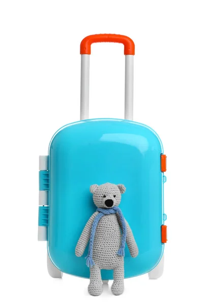 กระเป๋าเดินทางสีฟ้าเล็ก ๆ ที่มีสไตล์กับหมีเท็ดดี้บนพื้นหลังสีขาว — ภาพถ่ายสต็อก