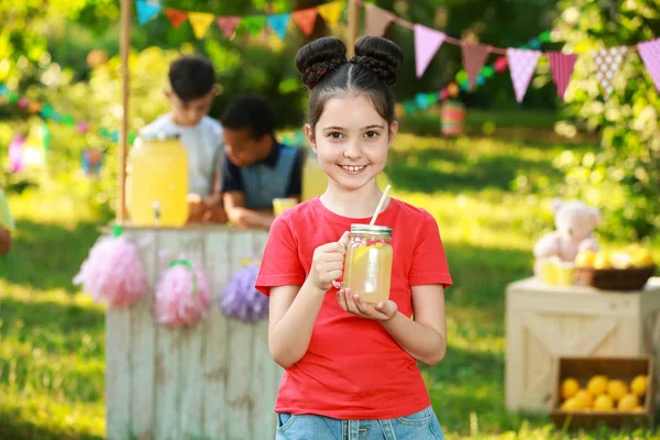 Cute little girl with natural lemonade in park. Summer refreshing drink — Stock Photo, Image