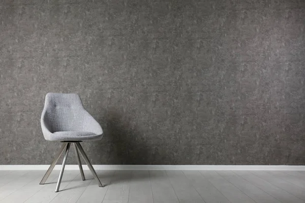 Silla moderna gris para diseño de interiores en suelo de madera en pared gris —  Fotos de Stock