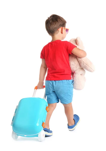 Menino bonito com brinquedo e mala azul no fundo branco — Fotografia de Stock