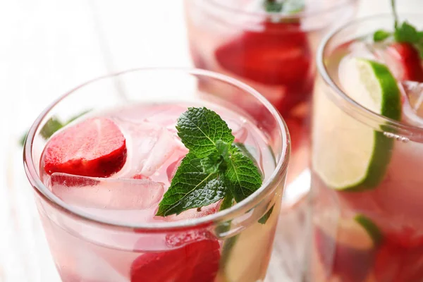 Ποτήρι δροσιστικό ποτό με φράουλα, λάιμ και μέντα στο τραπέζι, θέα στο κοντινό πλάνο — Φωτογραφία Αρχείου