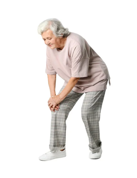 Портрет пожилой женщины с проблемами коленного сустава на сером фоне — стоковое фото