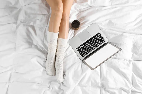 Yatakta oturan laptop ile kadın üst görünümü, çekim. Tasarım için mockup — Stok fotoğraf