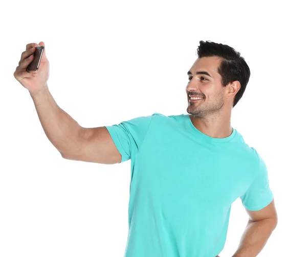 Jovem feliz tomando selfie no fundo branco — Fotografia de Stock
