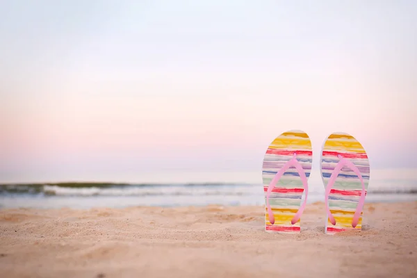 Infradito alla moda sulla sabbia vicino al mare, spazio per il testo. Accessori da spiaggia — Foto Stock