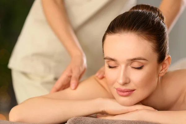 Beautiful young woman enjoying massage in spa salon — Stock Photo, Image