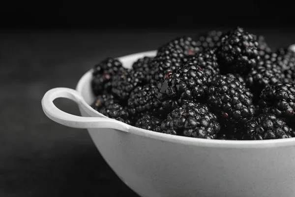 Ponceuse avec de savoureuses mûres mûres mûres sur fond sombre, gros plan — Photo