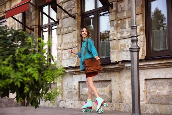 Feliz mujer joven con estilo con patines de ruedas vintage y bolso en la calle —  Fotos de Stock