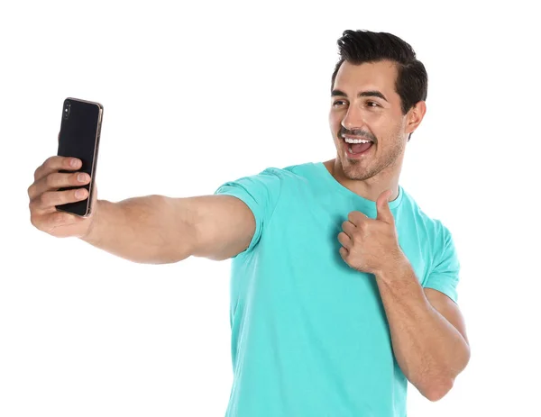 Szczęśliwy młody człowiek biorąc selfie na białym tle — Zdjęcie stockowe