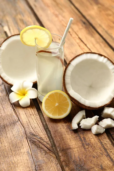 Composición con vaso de agua de coco y limón sobre mesa de madera — Foto de Stock