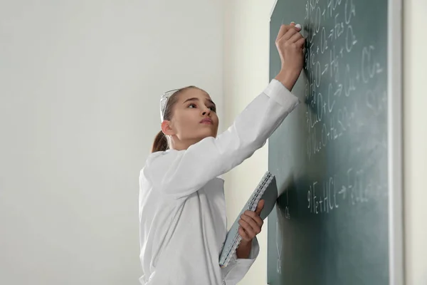 女学生在课堂上黑板上写化学公式 — 图库照片