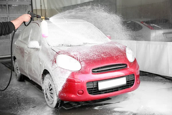 Worker cleaning automobile with high pressure water jet at car wash — Stock Photo, Image