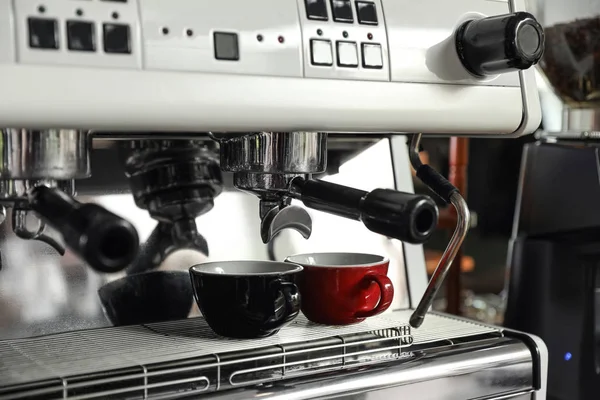 Modern coffee machine with cups in cafe, closeup — Stock Photo, Image