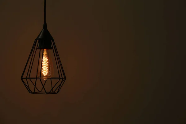 Předsazená žárovka na lustr proti tmavém pozadí, prostor pro text — Stock fotografie