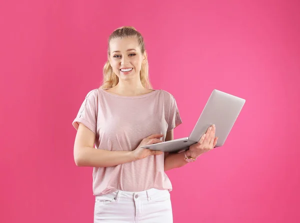 Portrait de jeune femme avec ordinateur portable sur fond rose — Photo