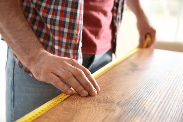 Man measuring wooden table, closeup. Construction tool — Stock Photo, Image