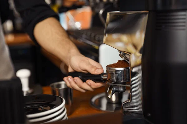 Barista pouring milled coffee from grinding machine into portafilter, closeup — Stock Photo, Image