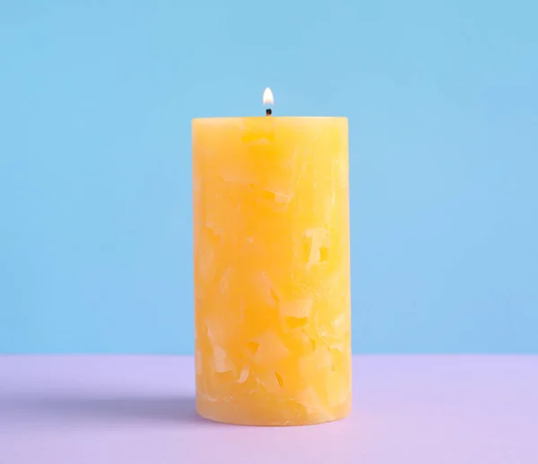 Alight scented wax candle on color background — Stock Photo, Image