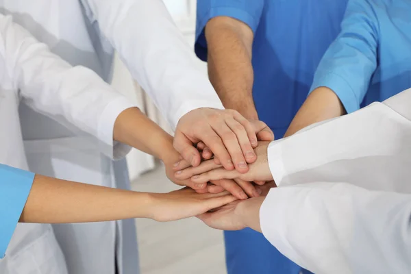 Team of medical workers holding hands together, closeup. Unity concept — Stock Photo, Image