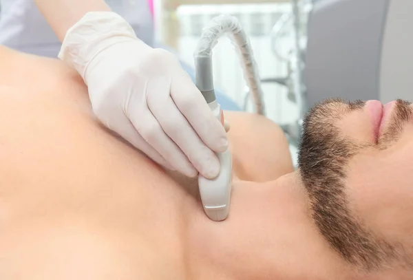 Médico que lleva a cabo el examen por ultrasonido de la glándula tiroides en clínica —  Fotos de Stock