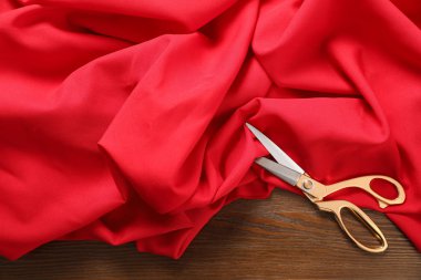 Kırmızı kumaş ve keskin makas ahşap masa, düz yatıyordu. Metin alanı