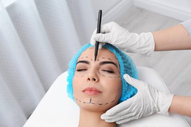 Klinikte kozmetik cerrahi operasyonu için kadın yüzüne Doktor çizim işaretleri