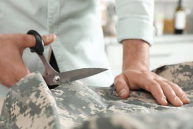Atölye, çekim içinde makas ile profesyonel terzi kesme Kamuflaj kumaş