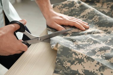 Atölye, çekim içinde makas ile profesyonel terzi kesme Kamuflaj kumaş