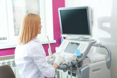Doktor, çalışma alanında ultrason teşhisi sonuçlarını analiz ediyor. Metin alanı