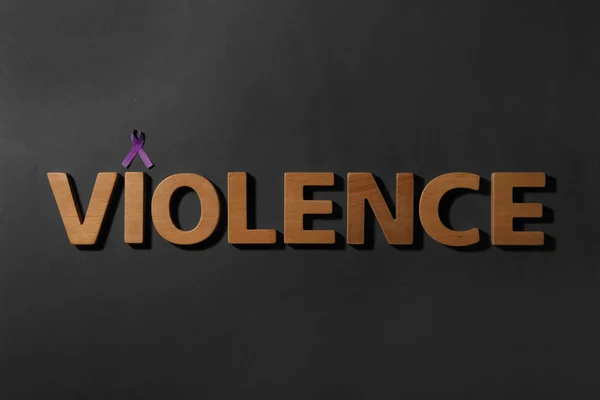 紫色意识丝带和文字暴力由黑色背景的木制字母,顶视图 — 图库照片