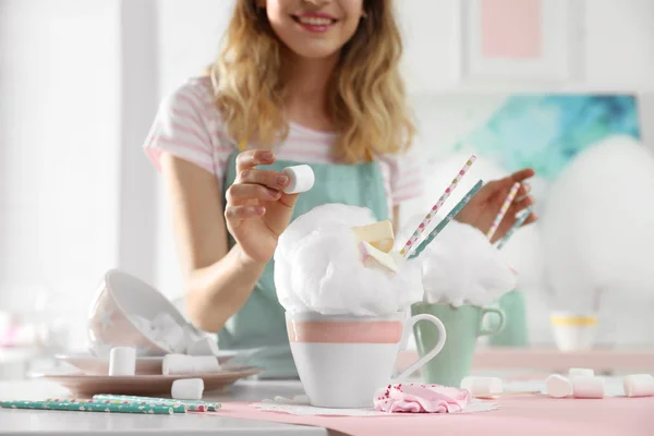 Jovem mulher decorando sobremesa de algodão doce com marshmallow à mesa, close-up — Fotografia de Stock