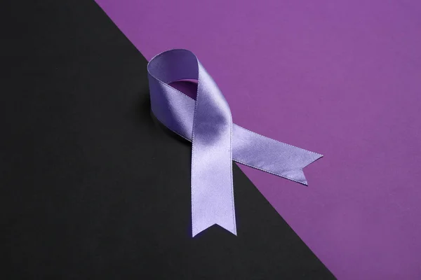 Satin purple awareness ribbon on color background
