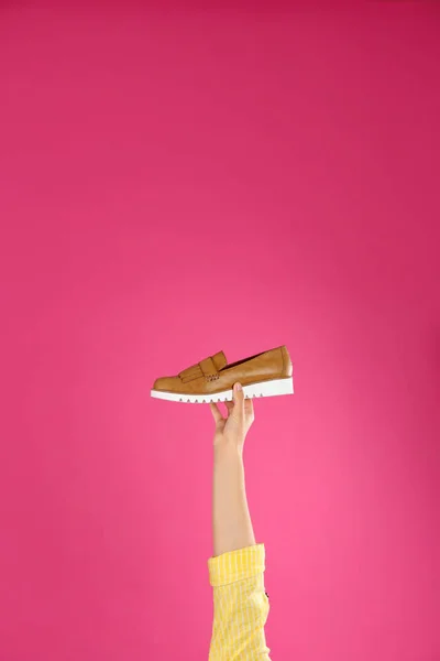Jovem segurando sapato confortável no fundo rosa, close-up — Fotografia de Stock