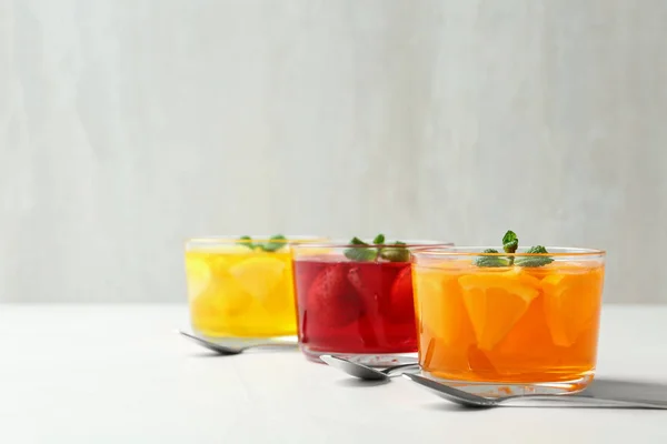 Ciotole di vetro di dessert di gelatina naturale su tavolo leggero, spazio per il testo — Foto Stock