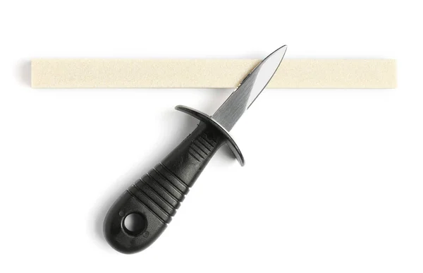 Ostron kniv och slipsten isolerade på vit, uppifrån — Stockfoto
