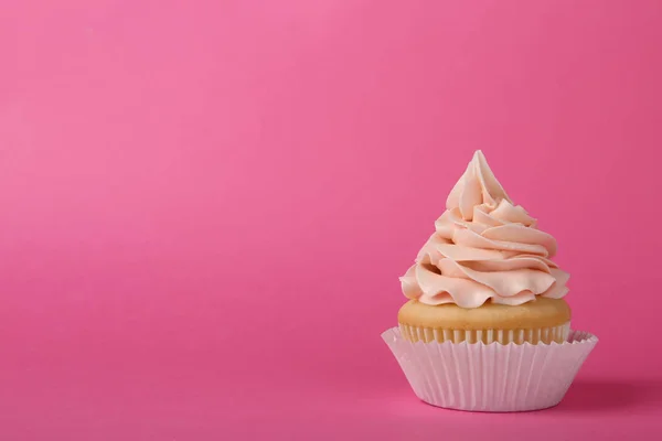 Gâteau savoureux avec crème sur fond rose, espace pour le texte — Photo
