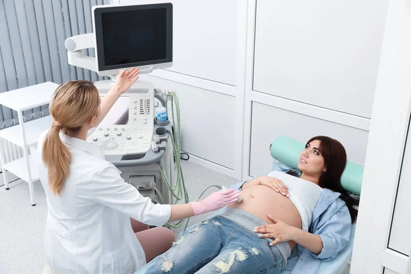 Νεαρή έγκυος γυναίκα που υποβάλλεται σε υπερηχογράφημα στη σύγχρονη κλινική — Φωτογραφία Αρχείου