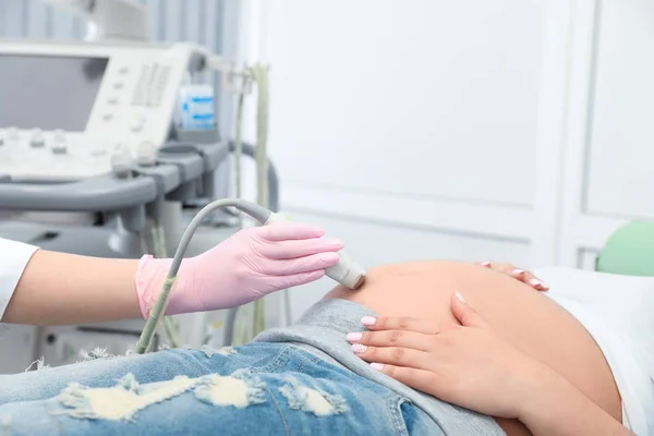 Junge Schwangere unterzieht sich in moderner Klinik einer Ultraschalluntersuchung — Stockfoto