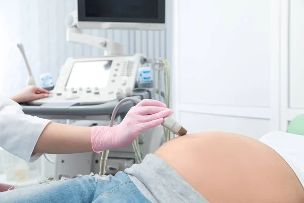 Young pregnant woman undergoing ultrasound scan in modern clinic, closeup view — Stock Photo, Image