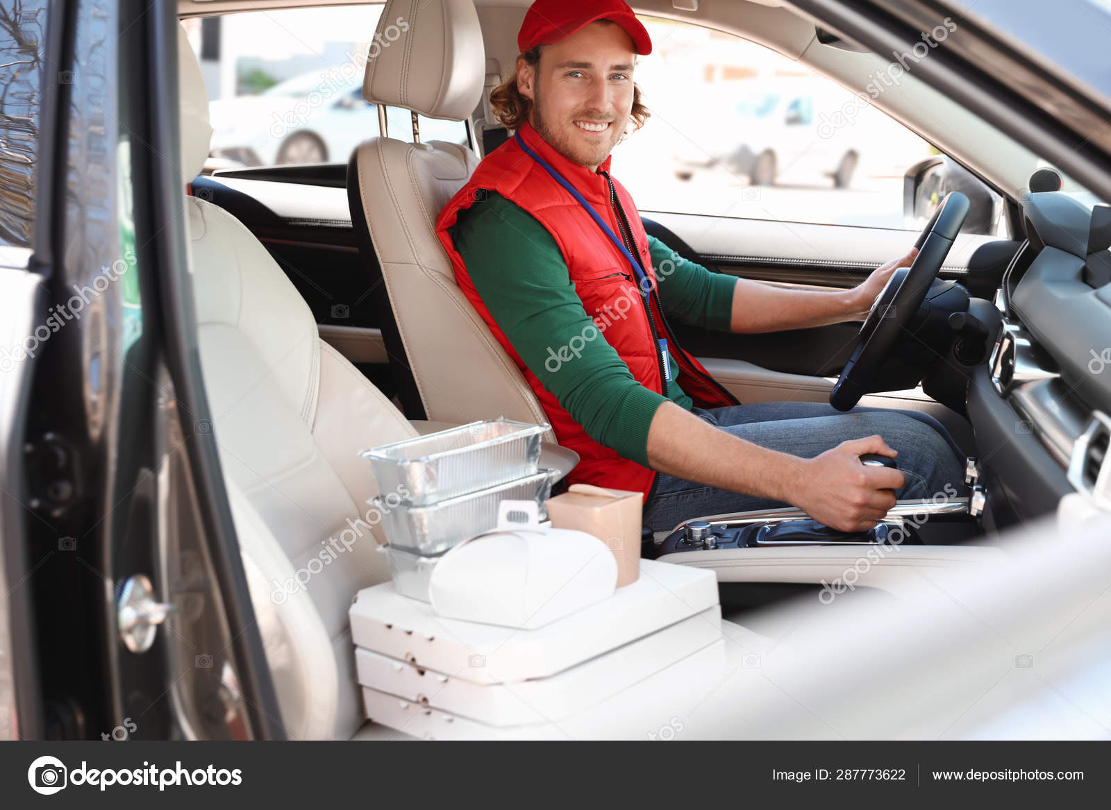 Male courier with orders in car. Food delivery service Stock Photo