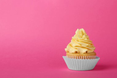 Pembe arka planda krem ile lezzetli cupcake, metin için alan