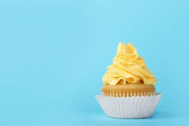Açık mavi arka planda krem ile lezzetli cupcake, metin için alan