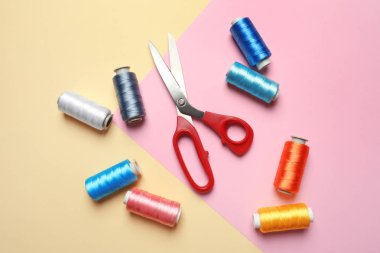 Renk arka plan üzerinde iplik ve dikiş makas Bobbins, düz yatıyordu